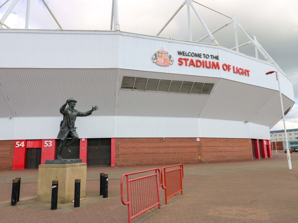 A stadium with a statue in front at 8 Percy Terrace in Whitburn