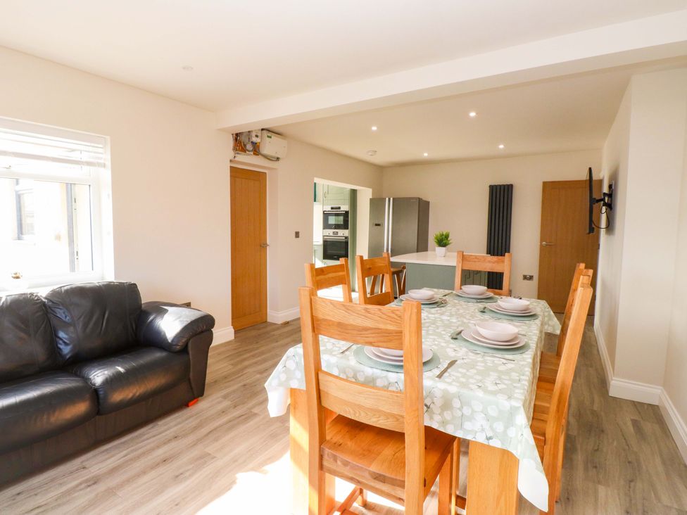 A dining room with a table and chairs at Morannedd in Morfa Nefyn