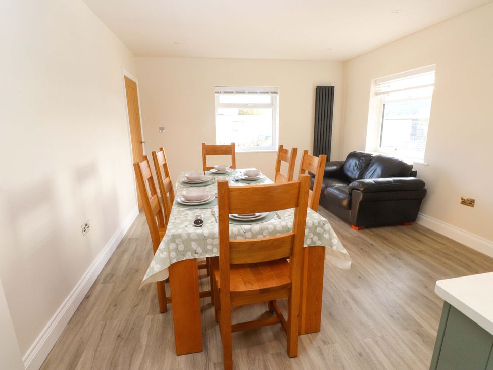 A dining room with a table and chairs at Morannedd Morfa Nefyn