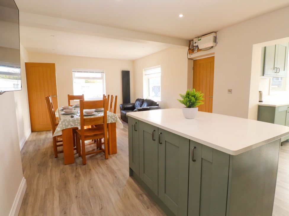 A dining room with a table and chairs at Morannedd Morfa Nefyn