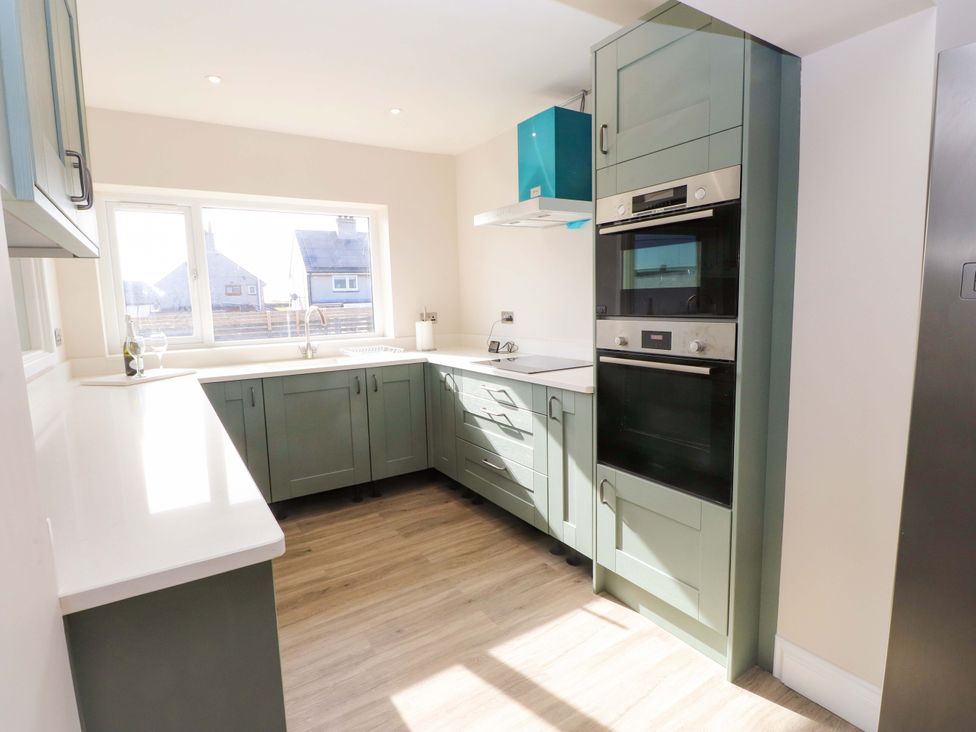 A kitchen with cabinets and an oven at Morannedd in Morfa Nefyn
