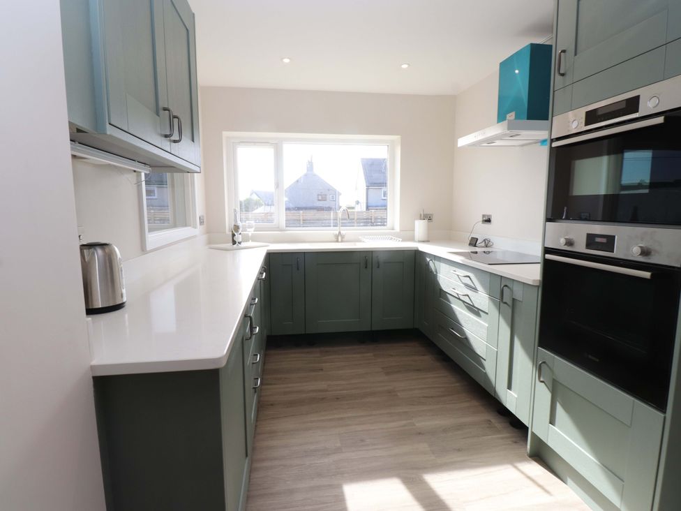 A kitchen with cabinets and appliances at Morannedd in Morfa Nefyn