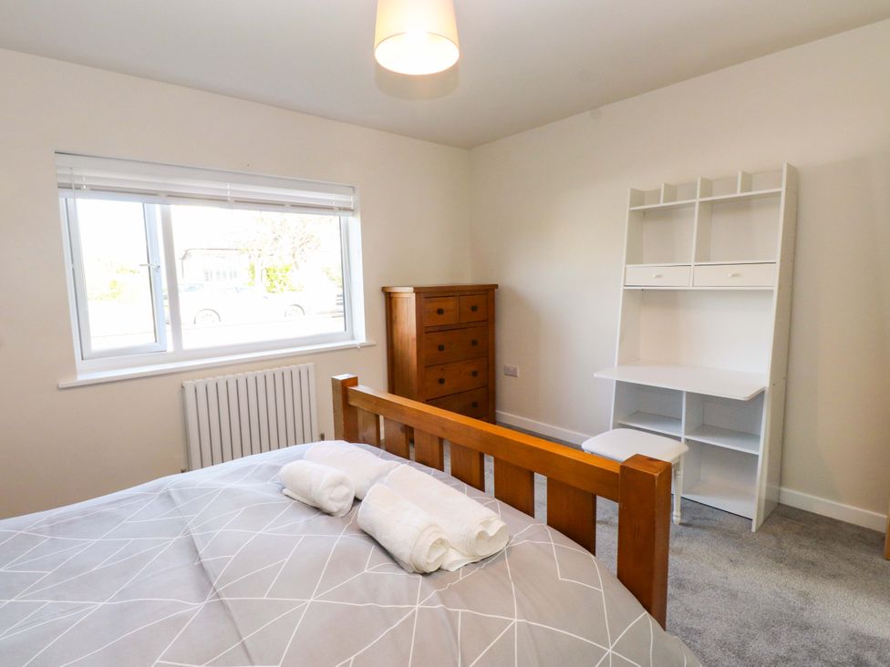 A bedroom with a bed, dresser, and desk at Morannedd in Morfa Nefyn