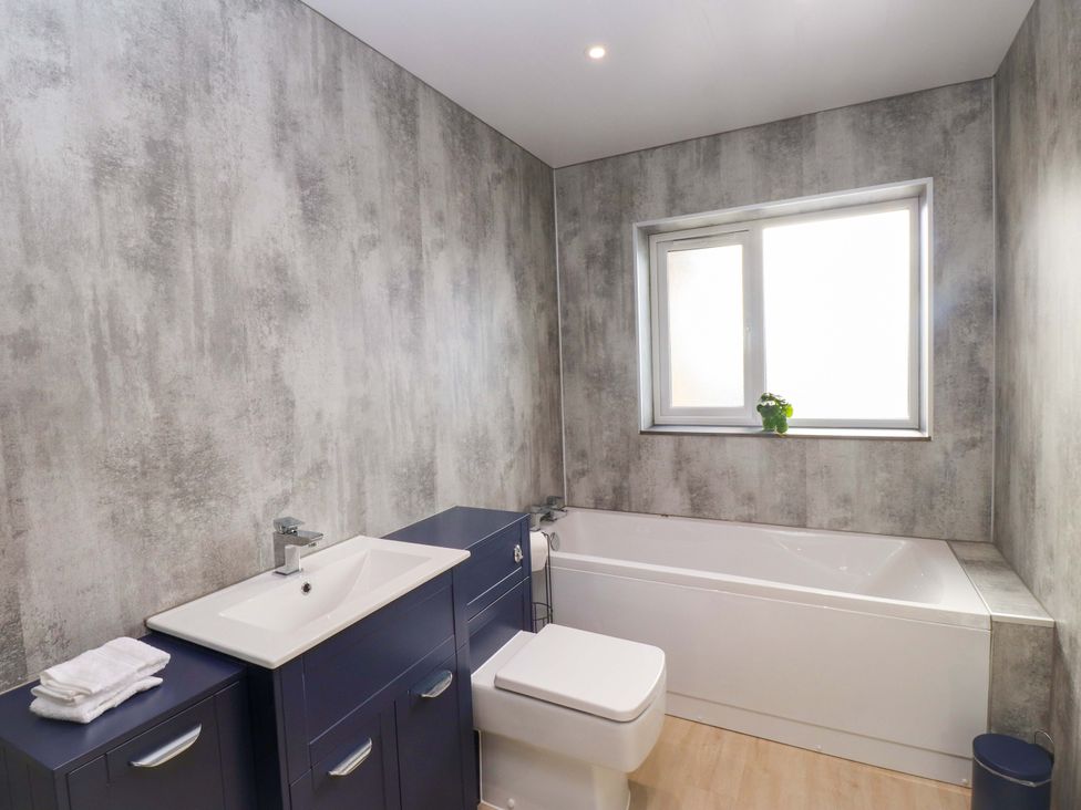 A bathroom with a bathtub, toilet, and sink at Morannedd in Morfa Nefyn