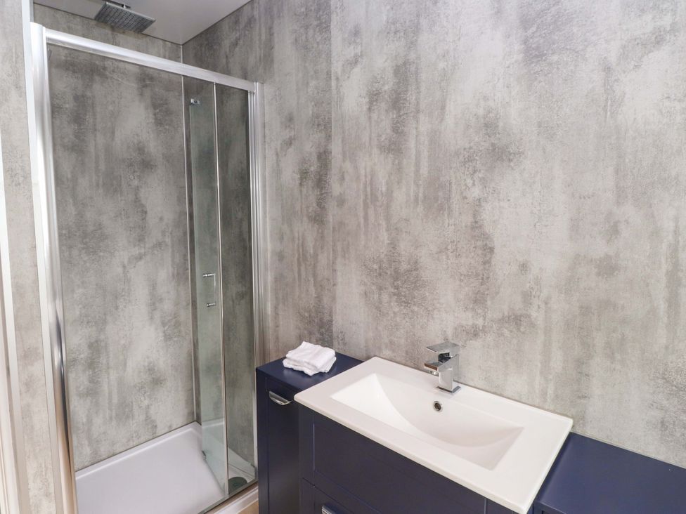 A bathroom with a shower and sink at Morannedd in Morfa Nefyn
