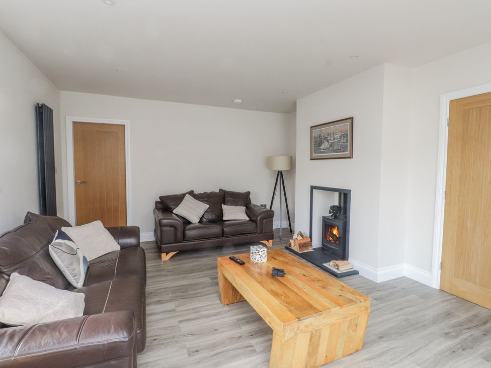 A living room with a sofa and fireplace at Morannedd in Morfa Nefyn