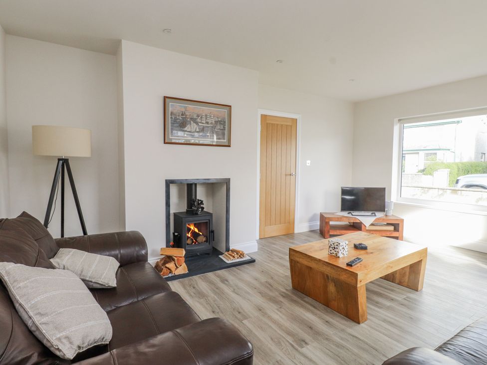 A living room with a sofa and fireplace at Morannedd in Morfa Nefyn