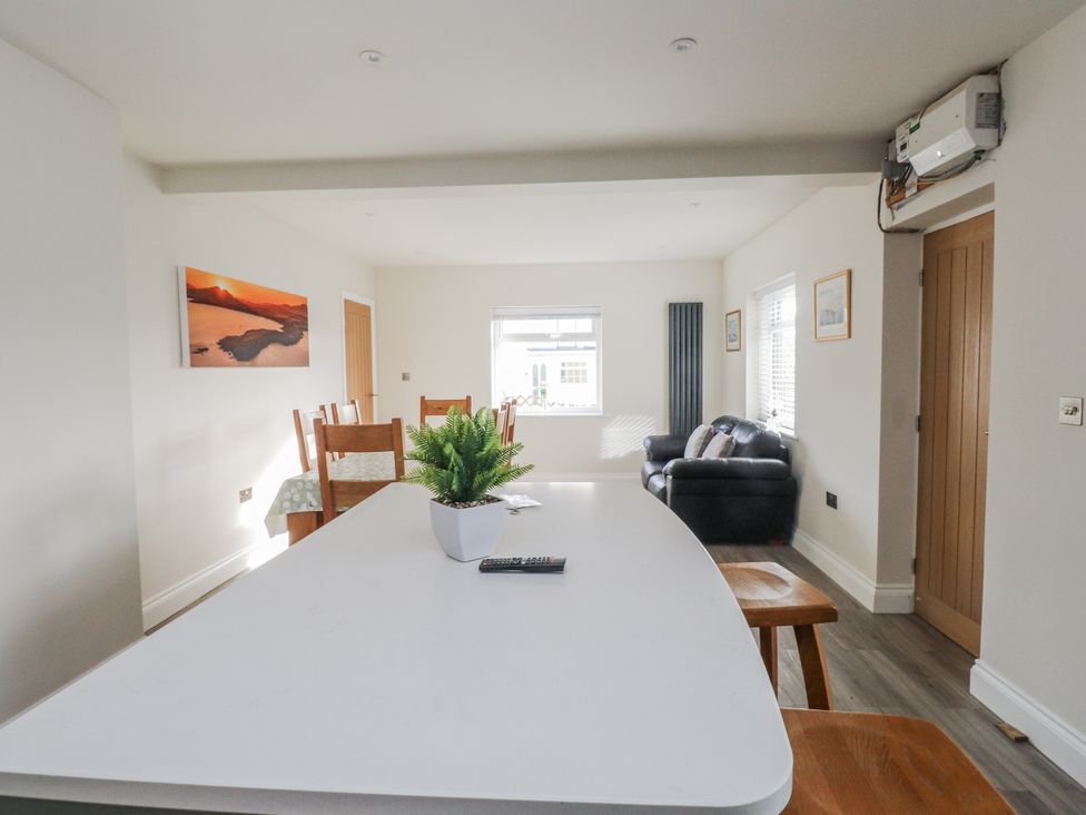 A dining room with a table and chairs at Morannedd Morfa Nefyn