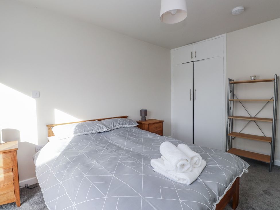 A bedroom with a bed and bedside table at Morannedd in Morfa Nefyn