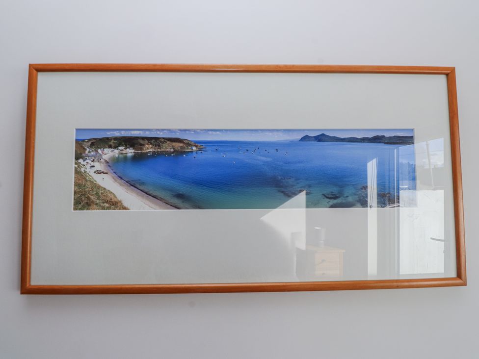 A panoramic photograph of a beach in a wooden frame at Morannedd in Morfa Nefyn