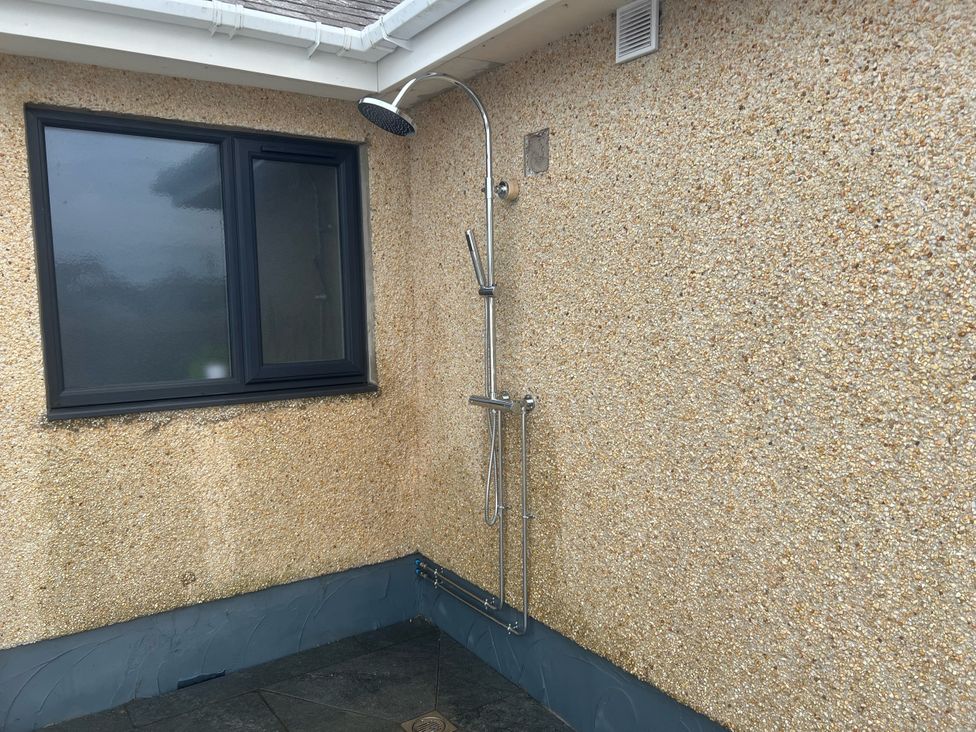 An outdoor shower installed on a wall at Morannedd in Morfa Nefyn