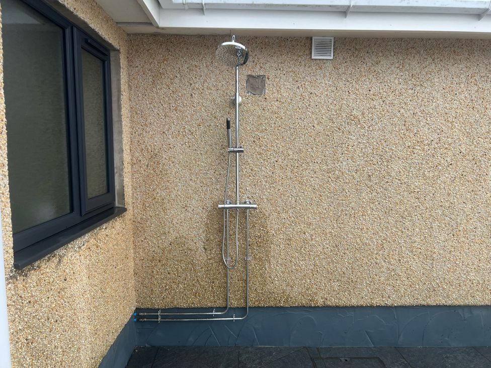 An outdoor shower on a wall at Morannedd in Morfa Nefyn