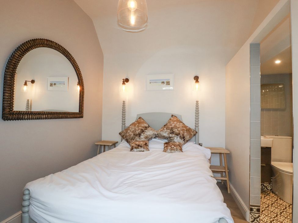 A bedroom with a bed and mirror at Beach View House in Newquay
