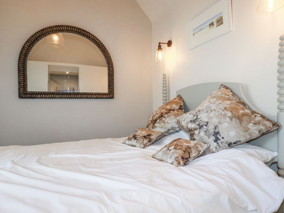 A bedroom with a bed and decorative pillows at Beach View House in Newquay
