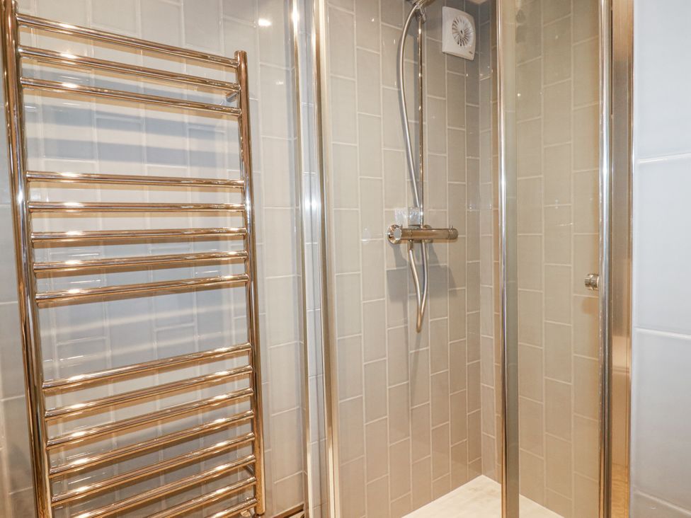 A shower with a showerhead and a towel radiator at Beach View House in Newquay