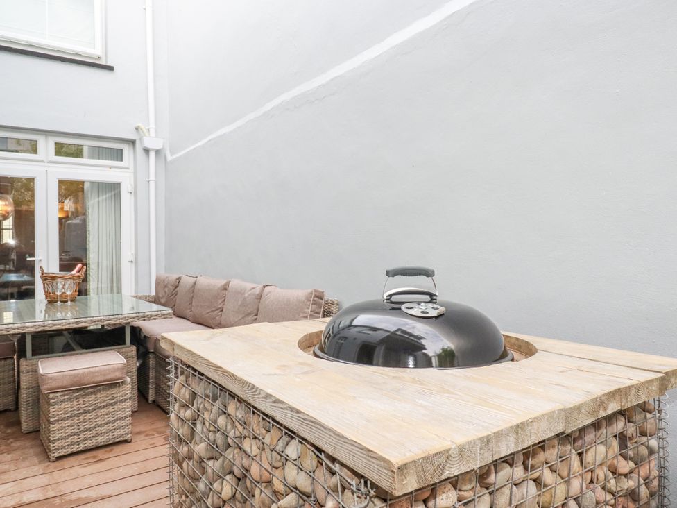 An outdoor patio with a grill and seating area at Beach View House in Newquay