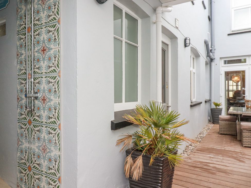 An outdoor dining area with potted plants and decorative tiles at Beach View House in Newquay
