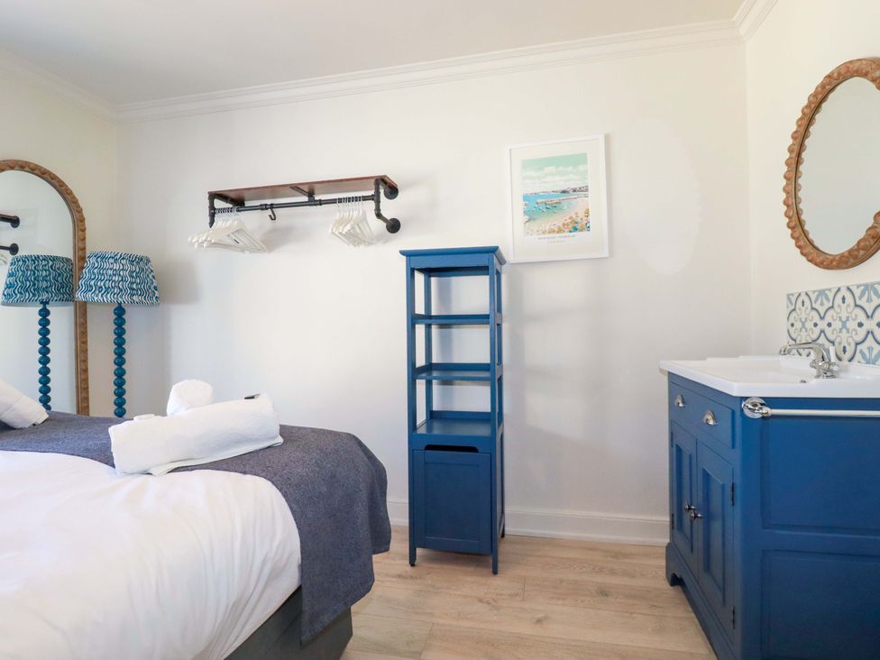 A bedroom with a bed and blue furniture at Beach View House in Newquay
