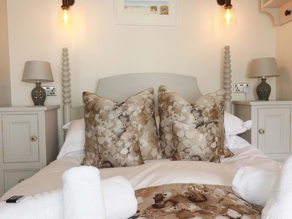 A bedroom with a bed and pillows at Beach View House in Newquay