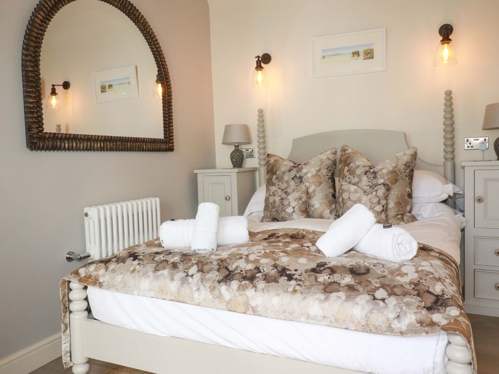 A bedroom with a bed and mirror at Beach View House in Newquay