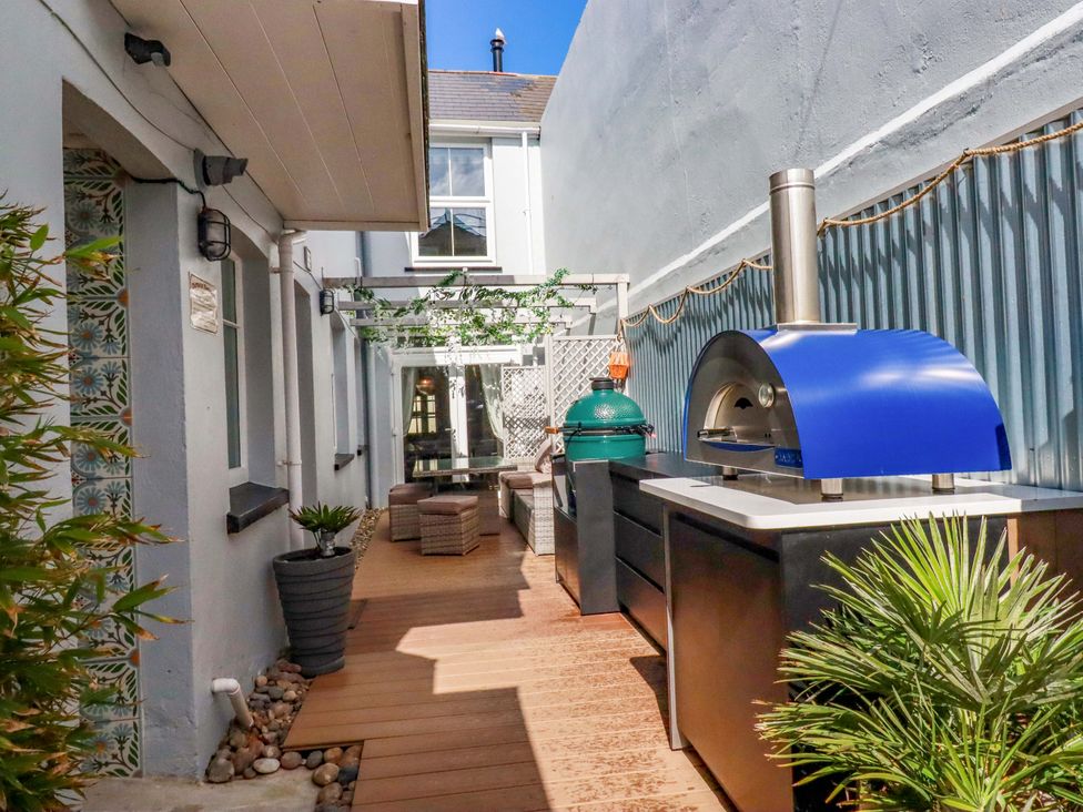 An outdoor space with a pizza oven and seating at Beach View House in Newquay