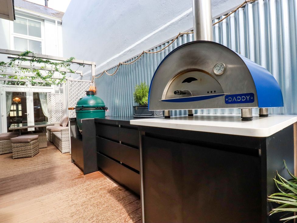 An outdoor kitchen with a pizza oven and barbecue grill at Beach View House in Newquay