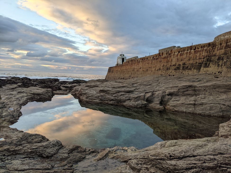 A coastal scene with water and rocks at Fairwinds in Portreath