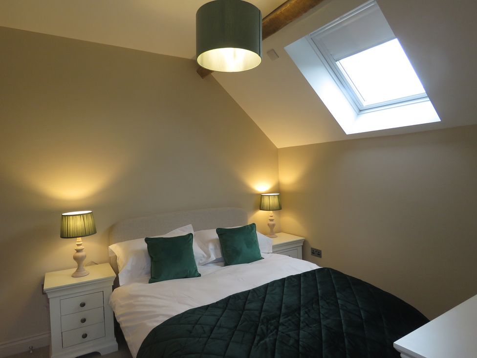 A bedroom with a bed and bedside tables at The Cartshed in Defford