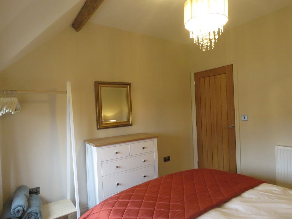 A bedroom with a bed and dresser at The Cartshed in Defford