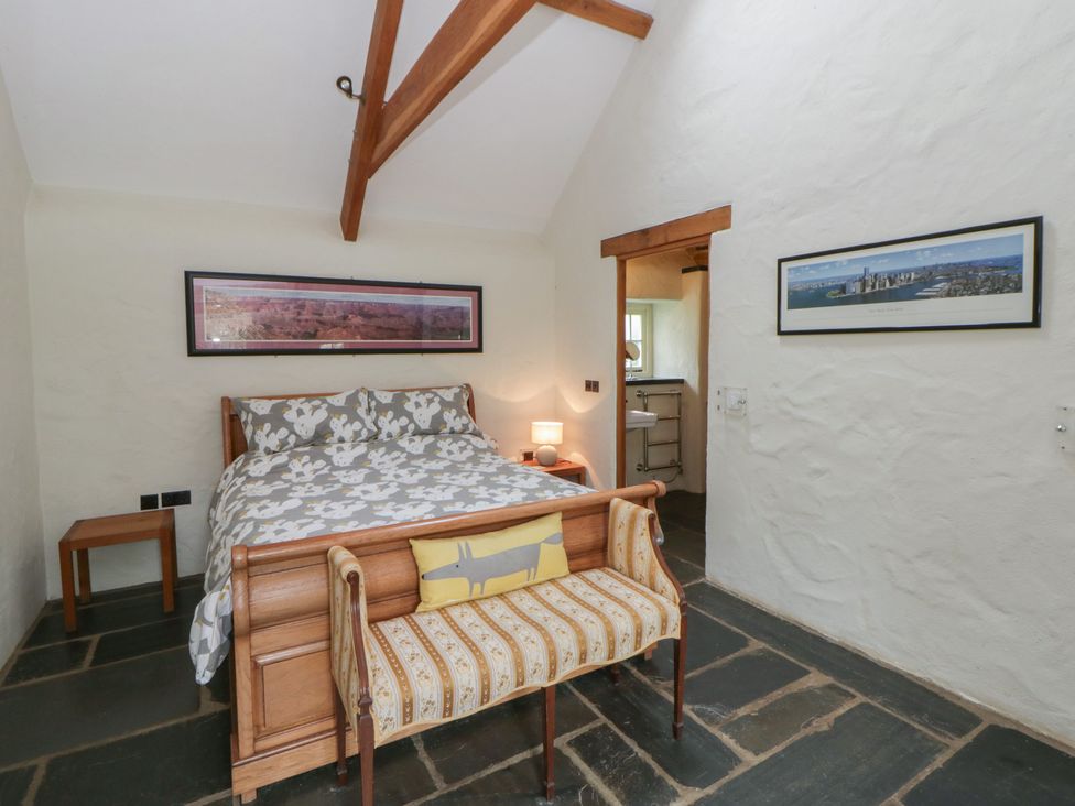 A bedroom with a bed and a bench at St Dogwells Barn near Wolfscastle