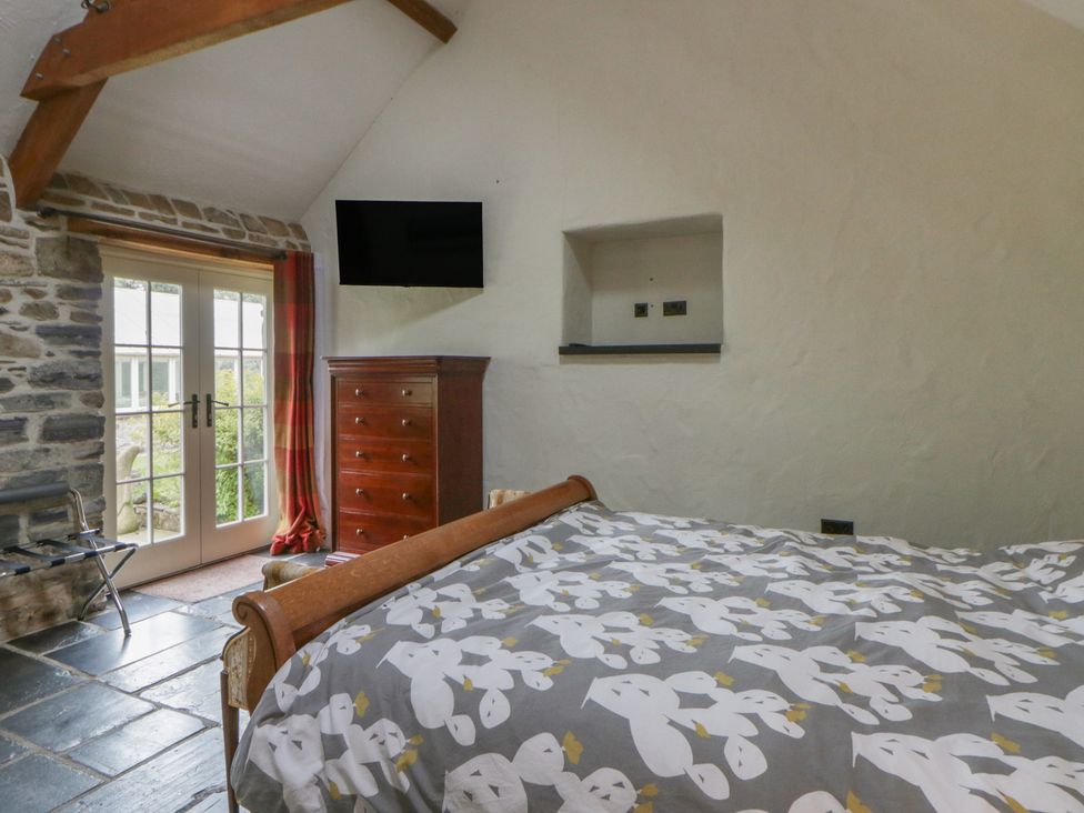 A bedroom with a bed and a dresser at St Dogwells Barn near Wolfscastle