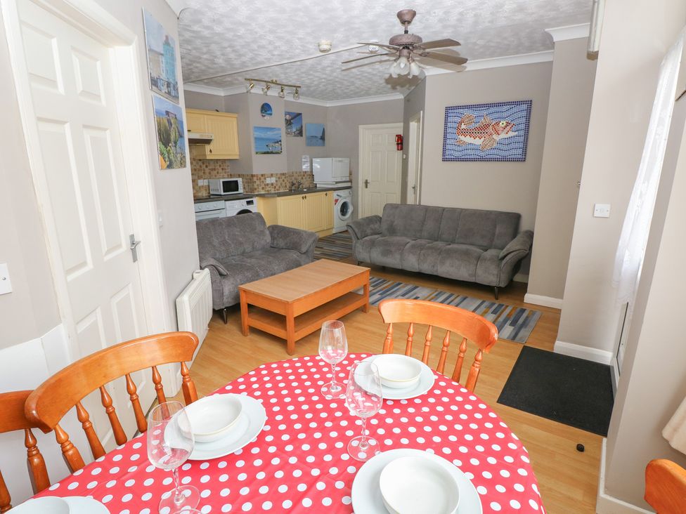 A kitchen and living area with dining table and sofa at The Hilton Retreat in Tenby