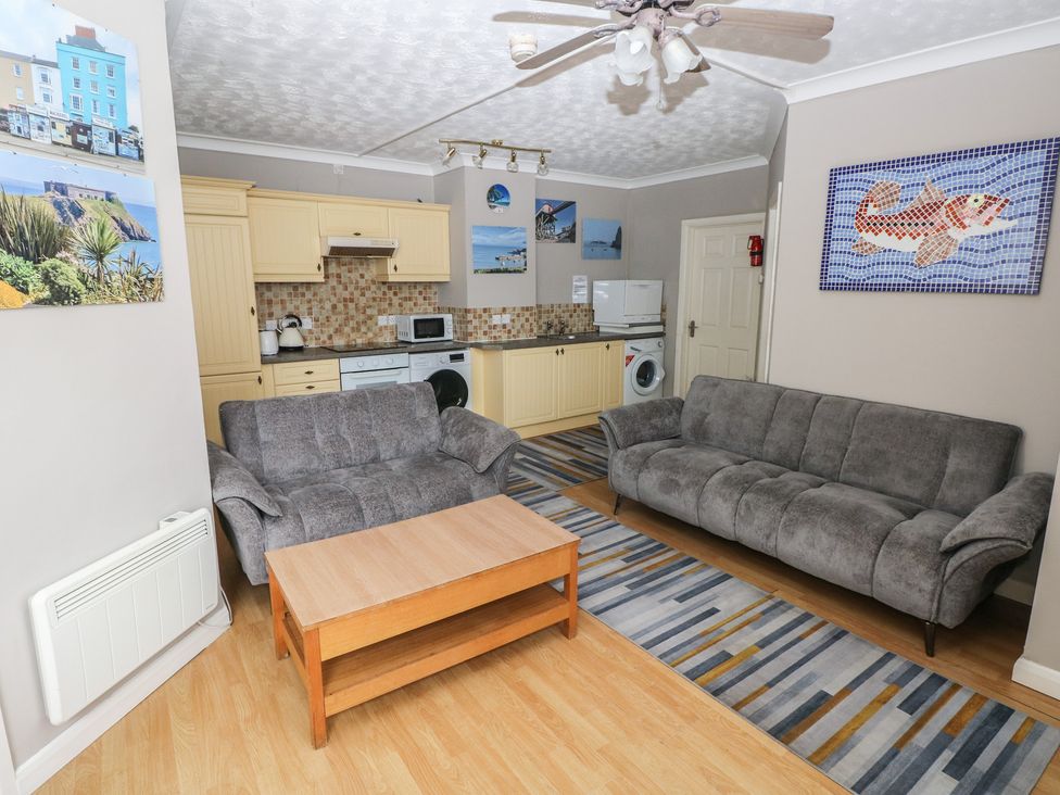 A living room with couches and kitchen area at The Hilton Retreat in Tenby