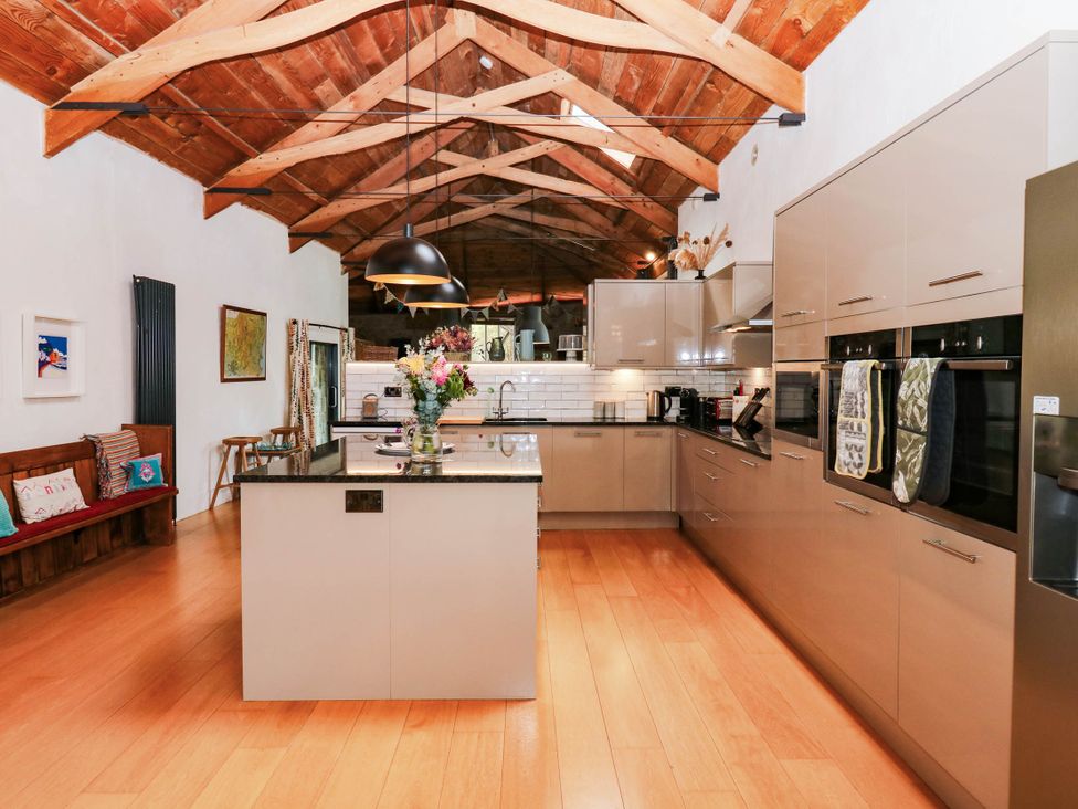 A kitchen with a central island and various appliances at Halshanger Barn in Newton Abbot