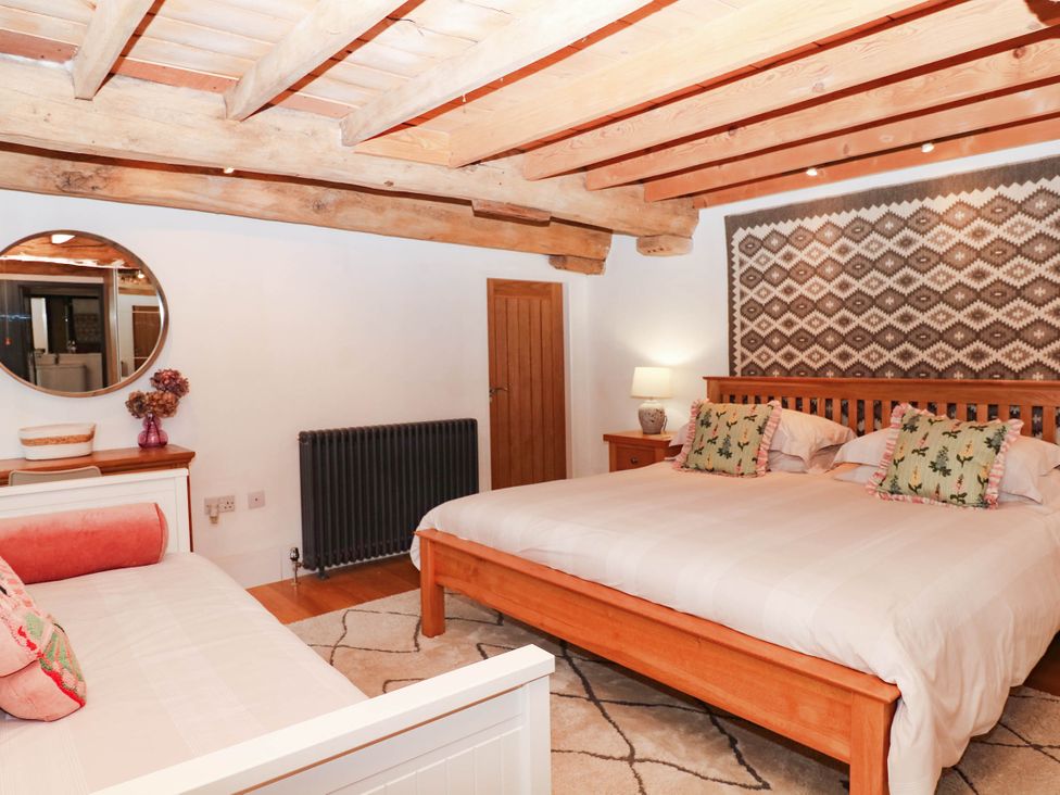 A bedroom with a large bed and furniture at Halshanger Barn in Newton Abbot