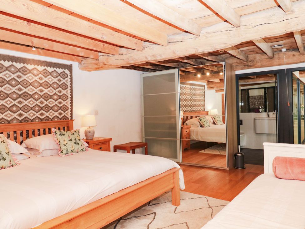 A bedroom with two beds and a bathroom at Halshanger Barn Newton Abbot