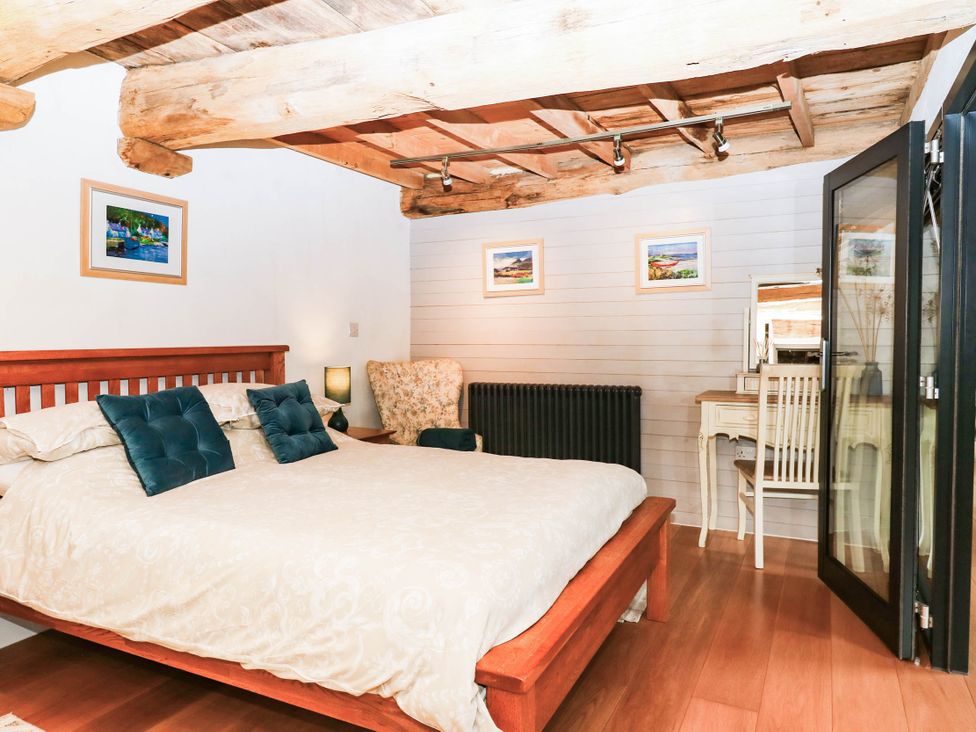 A bedroom with a bed and a desk at Halshanger Barn in Newton Abbot