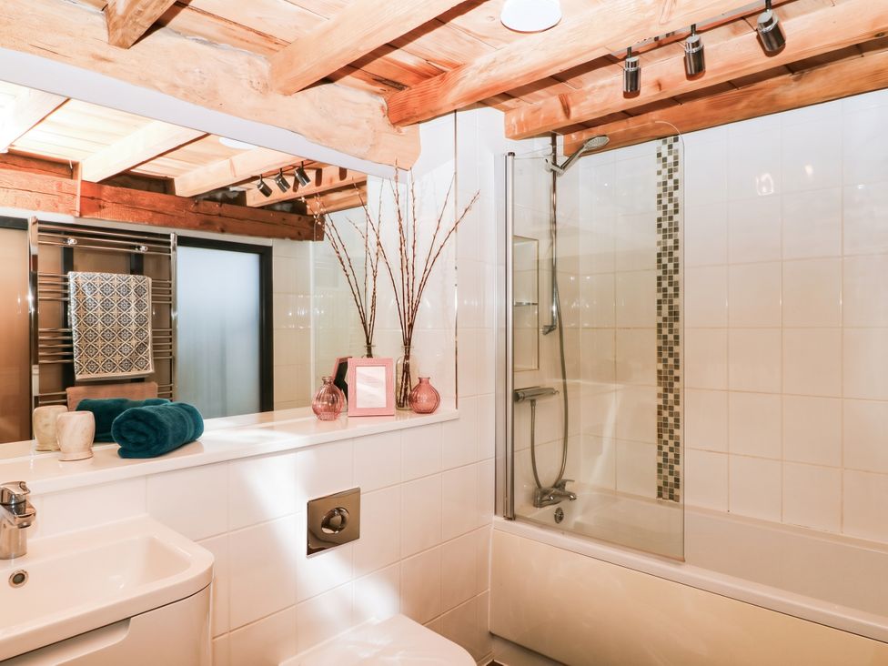 A bathroom with a bathtub, toilet, sink, and shower at Halshanger Barn in Newton Abbot