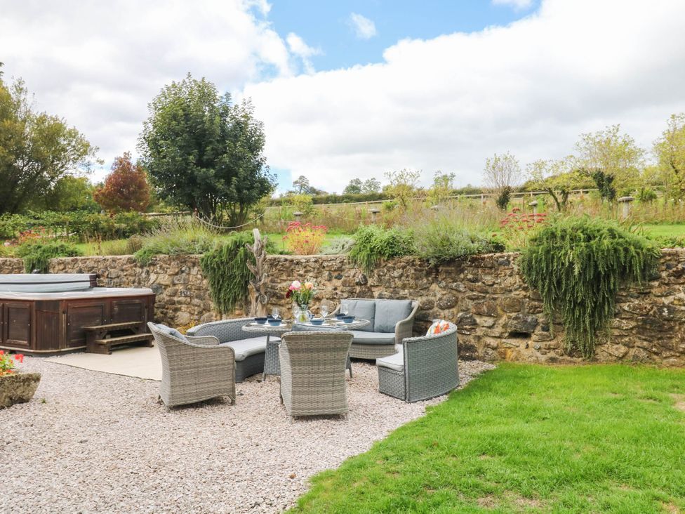 A garden with outdoor seating and a hot tub at Halshanger Barn Newton Abbot