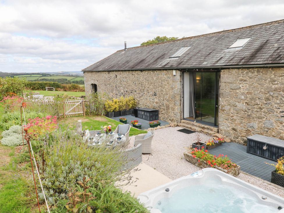 A garden with a hot tub and seating at Halshanger Barn in Newton Abbot