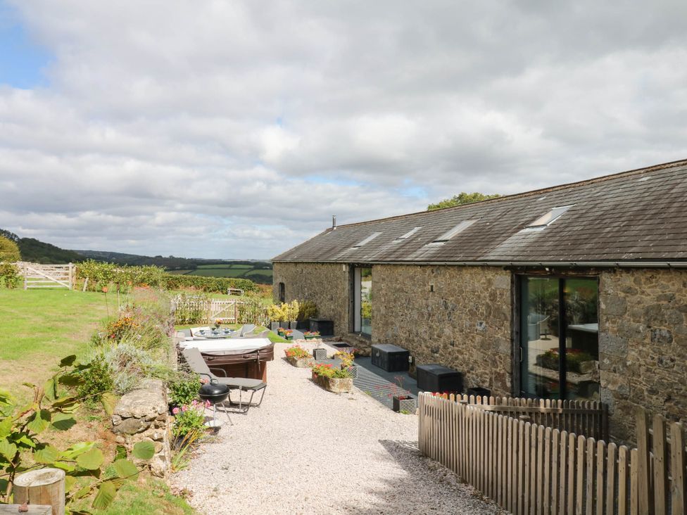 An outdoor area with a hot tub and seating at Halshanger Barn Newton Abbot