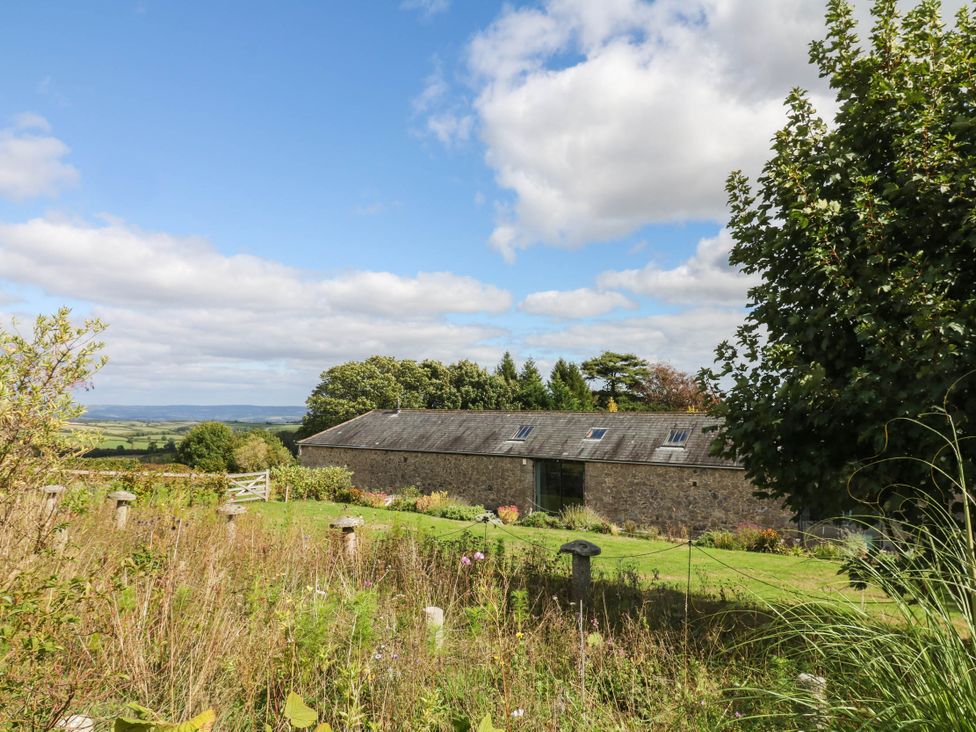 A barn with trees and grass at Halshanger Barn in Newton Abbot