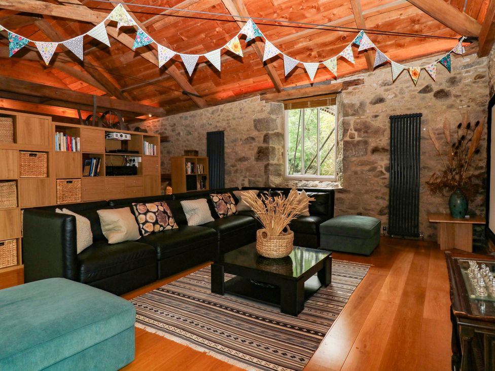 A living room with a sofa and coffee table at Halshanger Barn near Ashburton