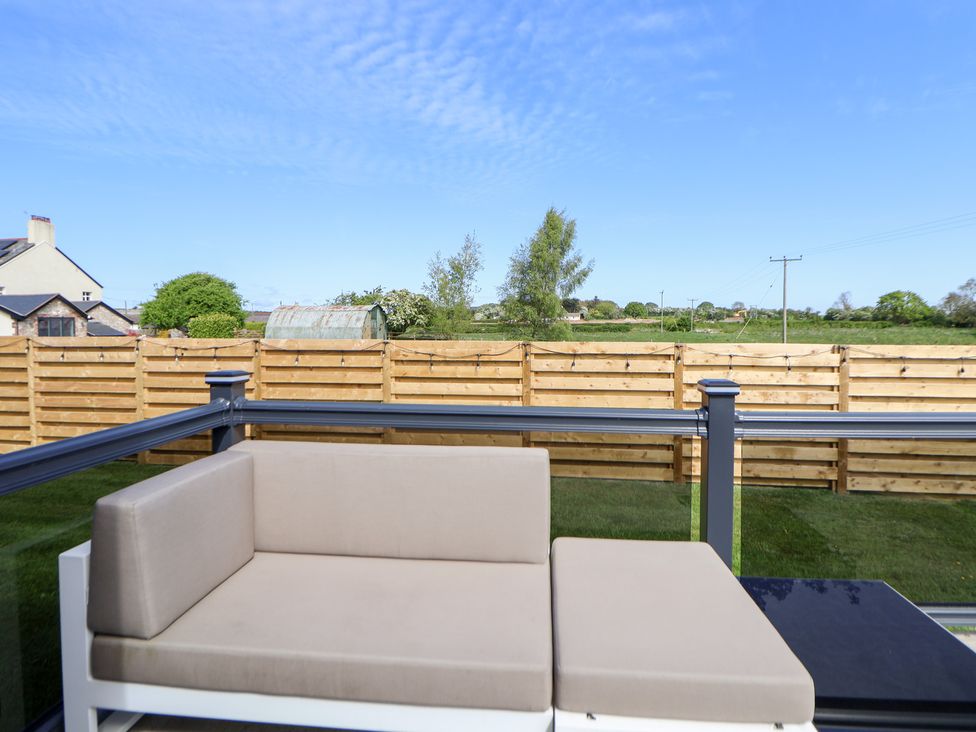 An outdoor area with seating and a view of the garden at The Lodge @ Racecourse House Babell near Holywell