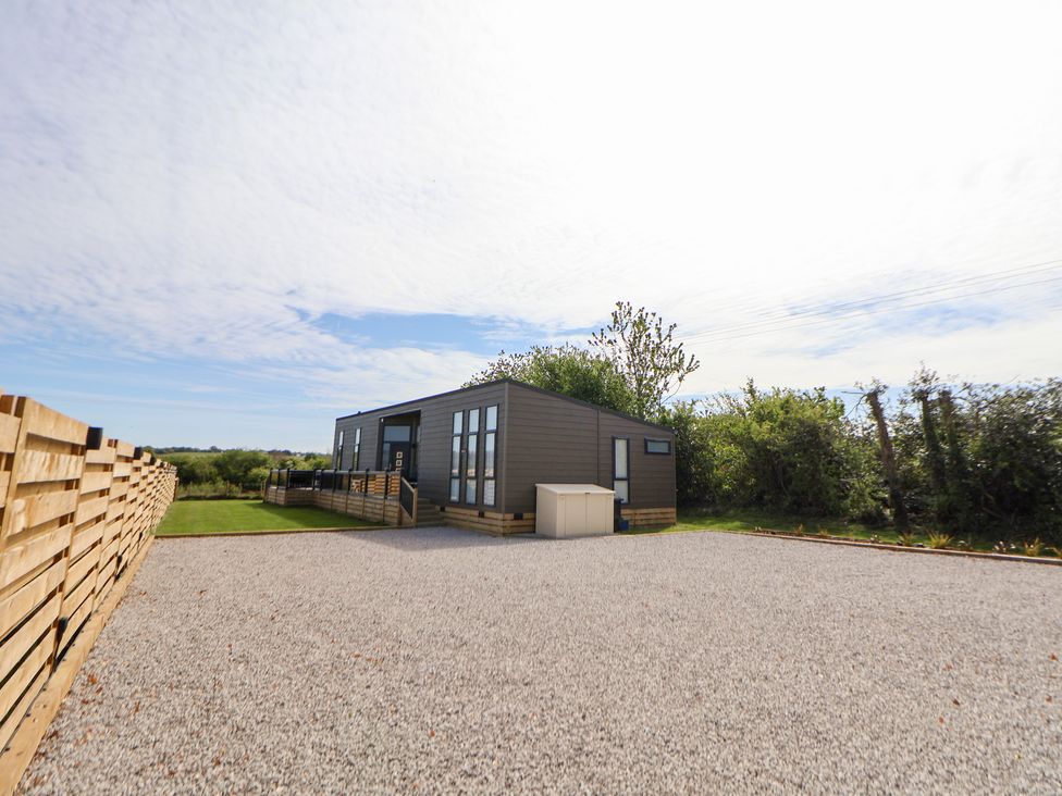 An outdoor area with a house and gravel at The Lodge @ Racecourse House in Babell near Holywell