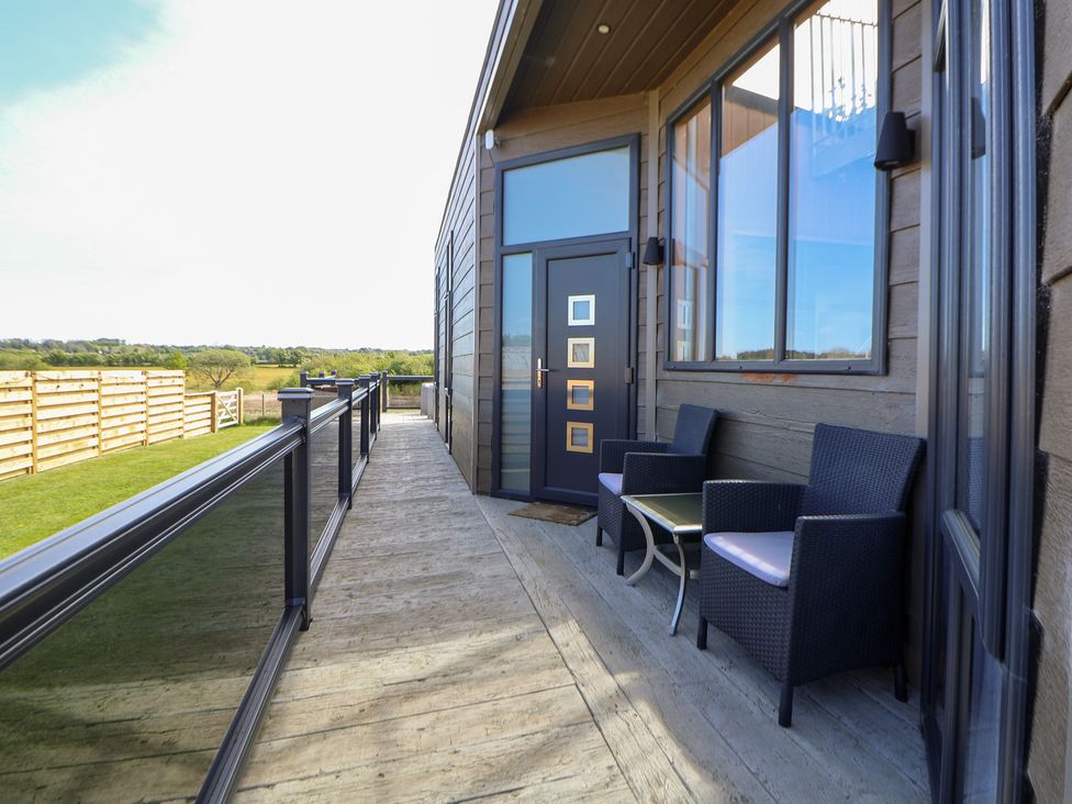 An outdoor area with seating and a door at The Lodge @ Racecourse House Babell near Holywell