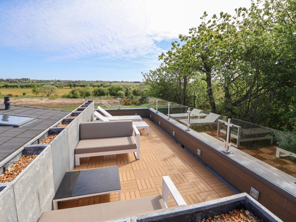 An outdoor terrace with seating and table at The Lodge @ Racecourse House Babell near Holywell
