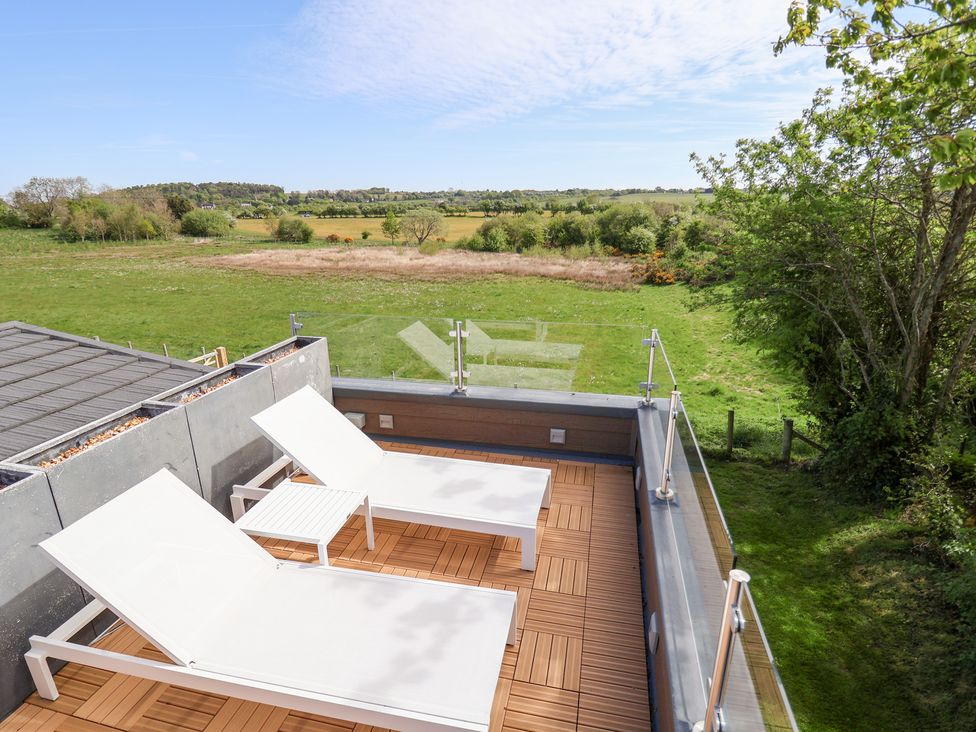 An outdoor terrace with lounge chairs at The Lodge @ Racecourse House in Babell near Holywell