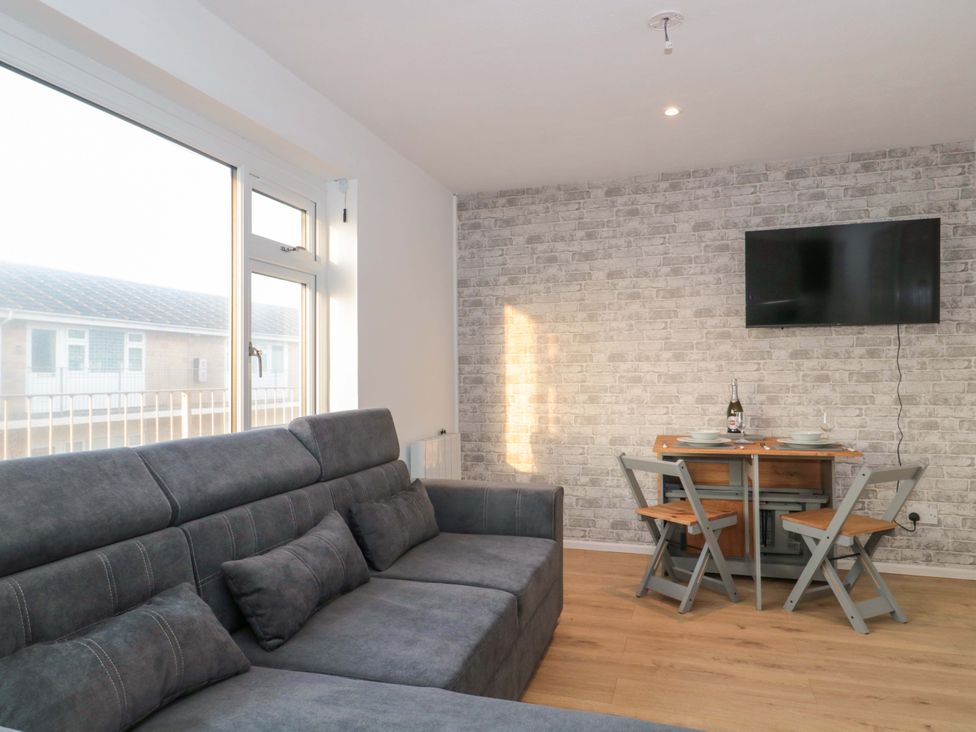 A living room with a sofa and dining set at Flat 24 in Brean