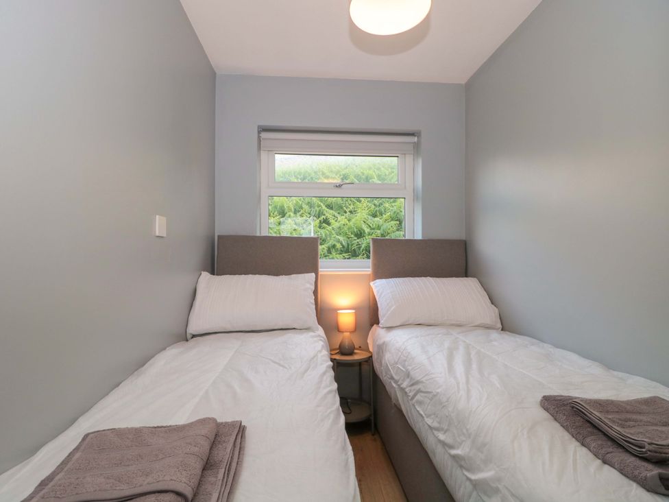 A bedroom with two single beds and a window at Flat 24 Brean